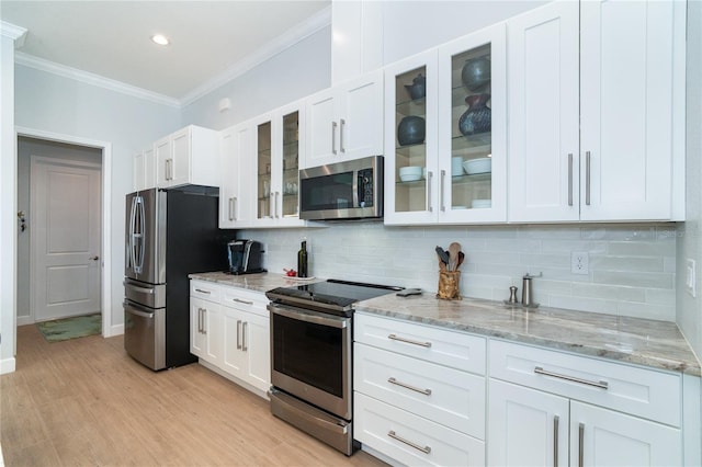 kitchen featuring light stone counters, appliances with stainless steel finishes, crown molding, and white cabinets