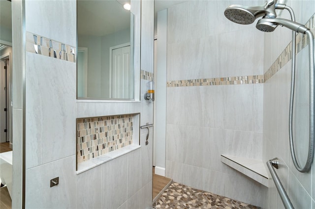 bathroom with tiled shower and ceiling fan