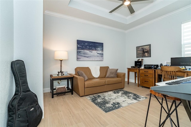 office area featuring ornamental molding, ceiling fan, light hardwood / wood-style floors, and a tray ceiling