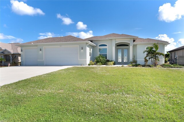 view of front facade with a garage, a front yard, and french doors