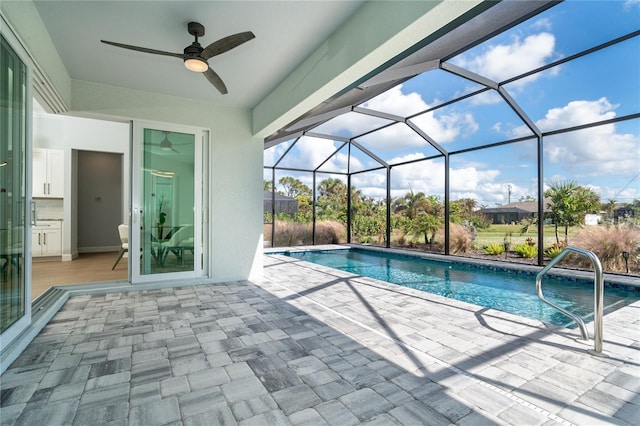 view of pool with ceiling fan, a patio area, and glass enclosure