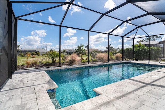 view of pool with glass enclosure and a patio area