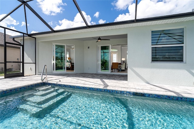 view of swimming pool featuring a patio, ceiling fan, and glass enclosure