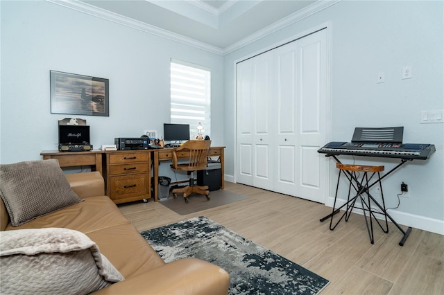 home office featuring ornamental molding, light hardwood / wood-style floors, and a tray ceiling