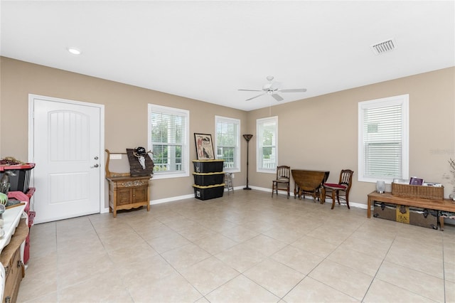 living area with ceiling fan and light tile patterned floors