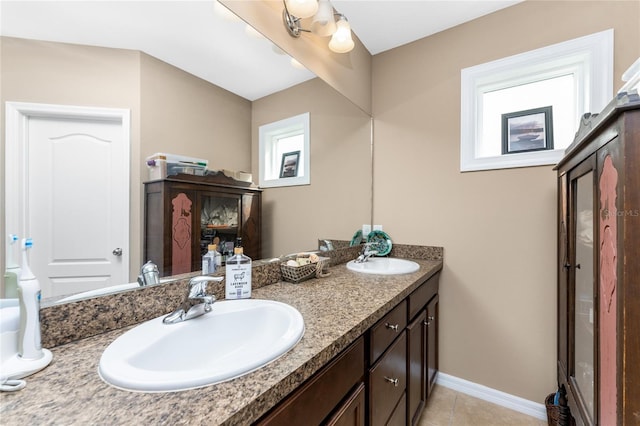 bathroom with tile patterned flooring, vanity, and a healthy amount of sunlight