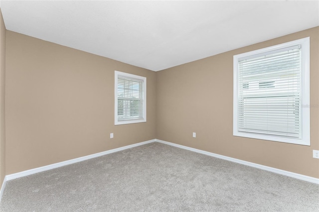 unfurnished room featuring light carpet