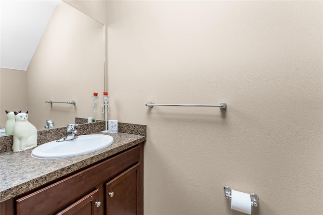 bathroom with vanity and lofted ceiling