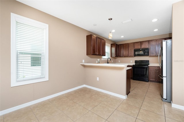 12753 Sagewood Dr, Venice, FL 34293 - kitchen with black appliances, a peninsula, light countertops, light tile patterned floors, and recessed lighting
