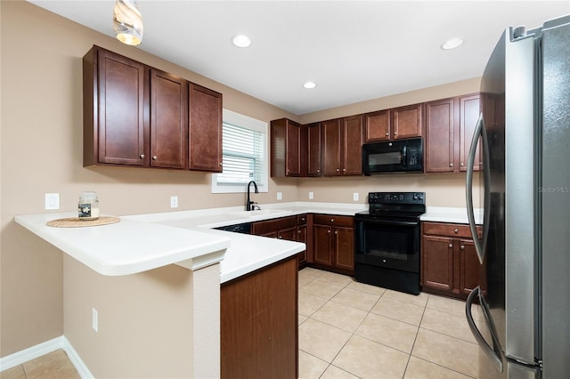 12753 Sagewood Dr, Venice, FL 34293 - kitchen with black appliances, a peninsula, light tile patterned floors, light countertops, and recessed lighting