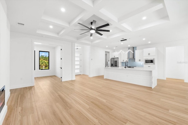 unfurnished living room featuring beam ceiling, ceiling fan, light hardwood / wood-style flooring, and coffered ceiling