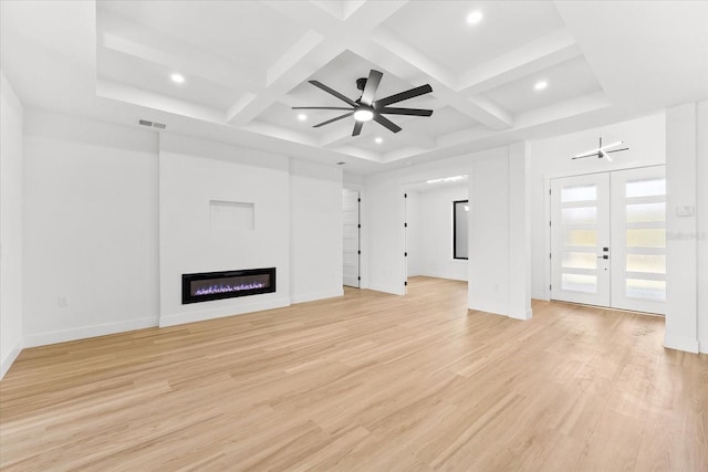 unfurnished living room featuring ceiling fan, light wood-type flooring, french doors, and coffered ceiling