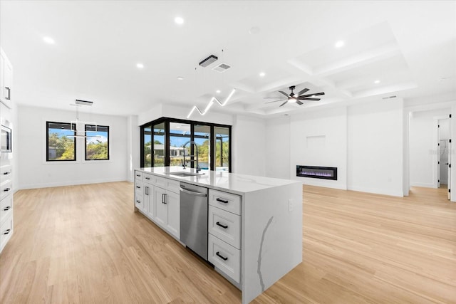 kitchen featuring a kitchen island with sink, coffered ceiling, white cabinets, stainless steel dishwasher, and light hardwood / wood-style floors