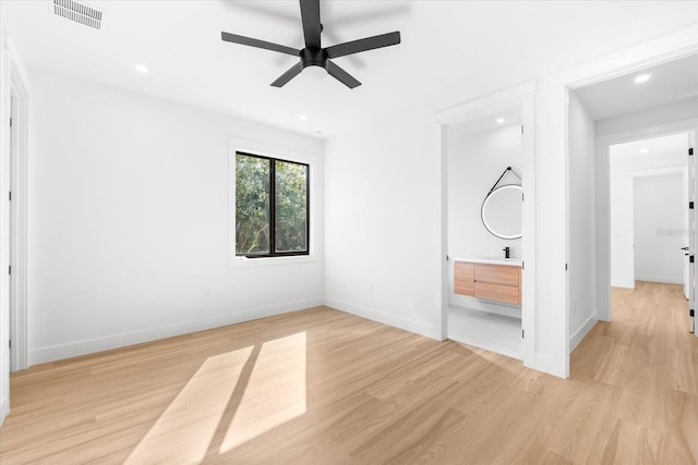 unfurnished bedroom featuring connected bathroom, light hardwood / wood-style flooring, ceiling fan, and sink