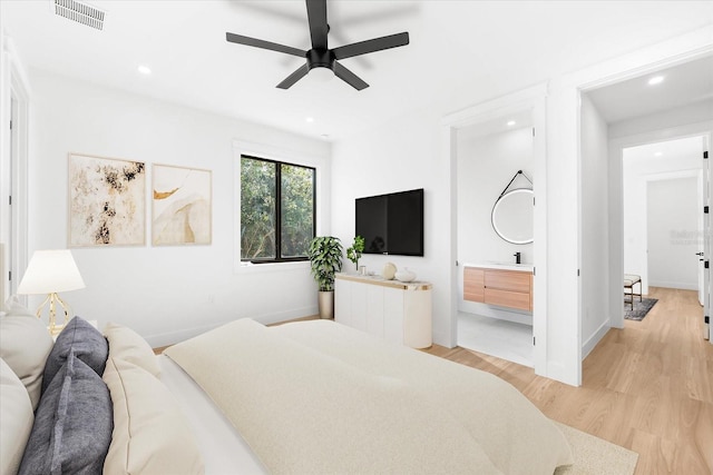 bedroom with ceiling fan, sink, light hardwood / wood-style flooring, and ensuite bath