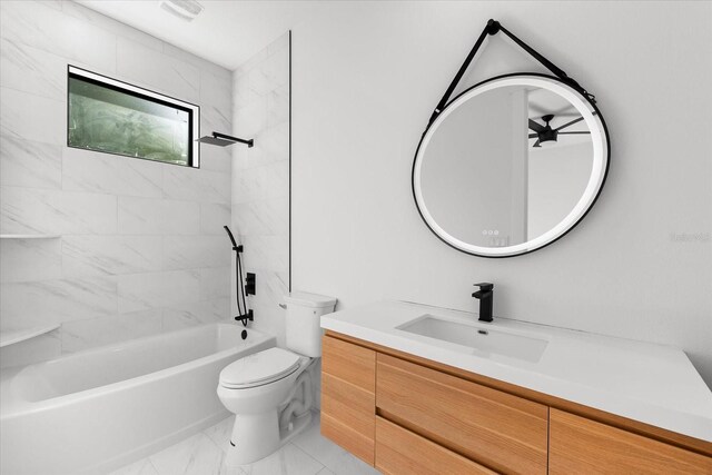 full bathroom featuring vanity, tiled shower / bath combo, and toilet