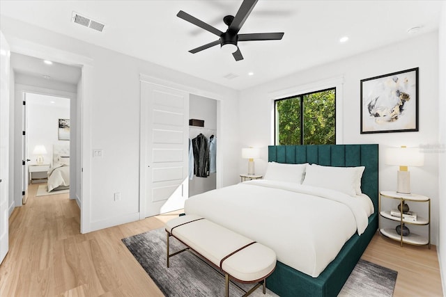 bedroom with light hardwood / wood-style flooring, a closet, and ceiling fan