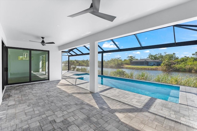 view of pool with a lanai, ceiling fan, a water view, and a patio