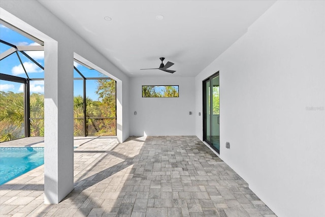 unfurnished sunroom featuring a pool, a wealth of natural light, and ceiling fan