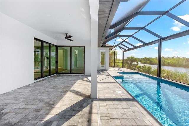 view of pool featuring glass enclosure, ceiling fan, and a patio area