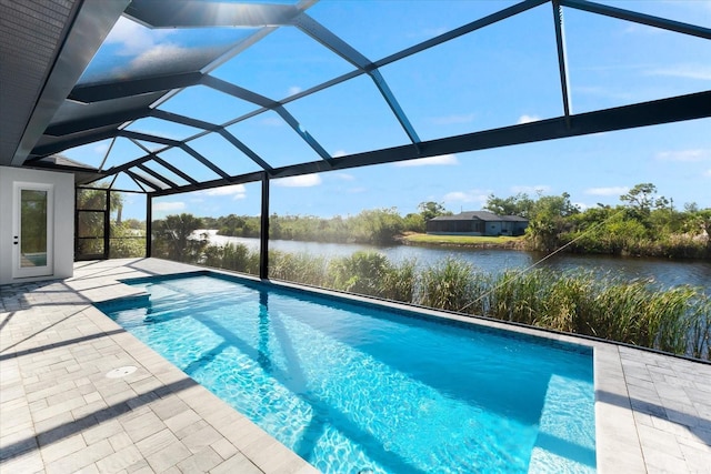 view of pool featuring a lanai, a patio area, and a water view