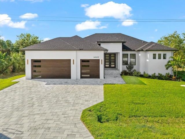 prairie-style house with french doors, a front lawn, and a garage