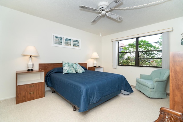 bedroom featuring ceiling fan, a textured ceiling, and carpet floors