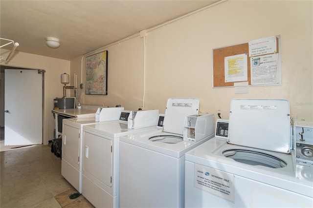 clothes washing area with washing machine and dryer and water heater