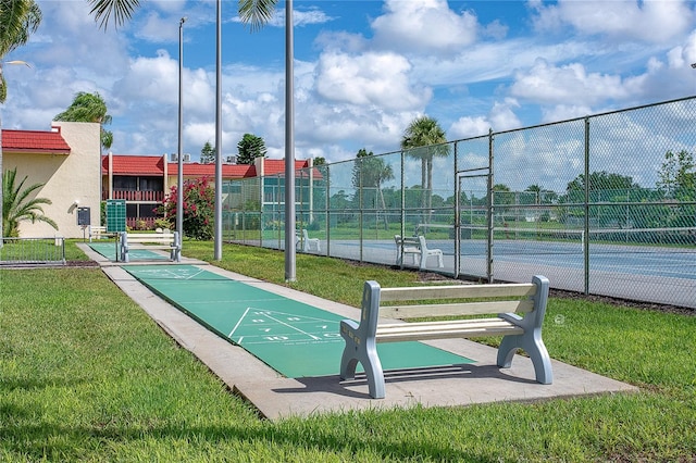 view of community with a lawn and tennis court