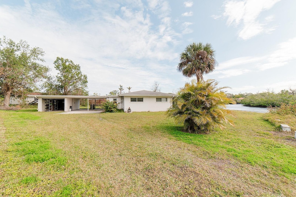 view of yard featuring a water view and a carport