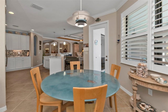 tiled dining space with crown molding and sink