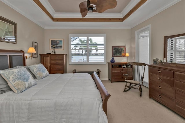 carpeted bedroom with ornamental molding, ceiling fan, and a tray ceiling