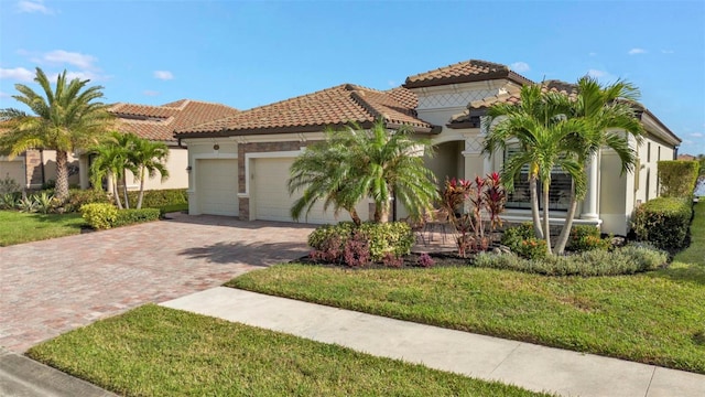 mediterranean / spanish-style home with a garage and a front lawn