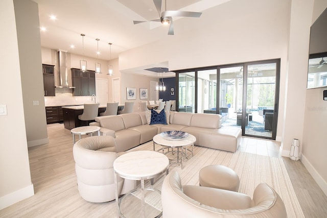 living room featuring light hardwood / wood-style floors and ceiling fan with notable chandelier