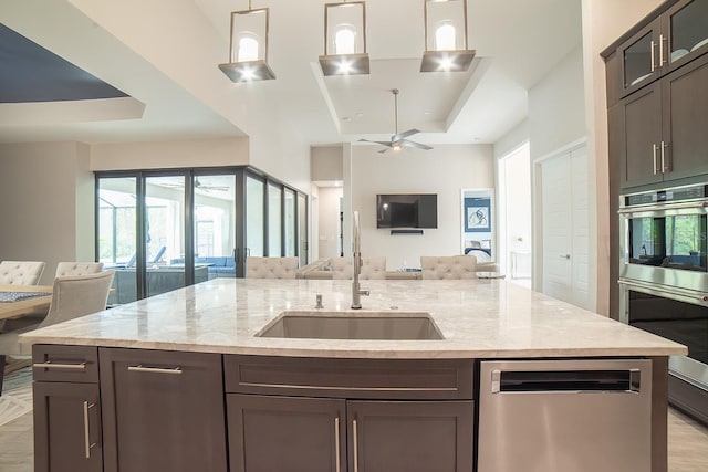 kitchen featuring ceiling fan, light stone countertops, stainless steel appliances, and decorative light fixtures