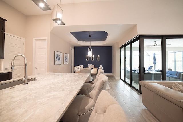 interior space featuring a wealth of natural light, sink, hardwood / wood-style floors, and ceiling fan with notable chandelier