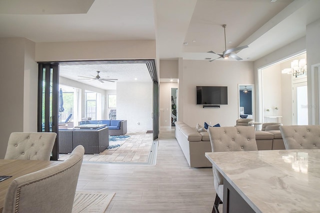 living room with ceiling fan with notable chandelier