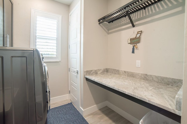 clothes washing area with light hardwood / wood-style floors and washer / dryer