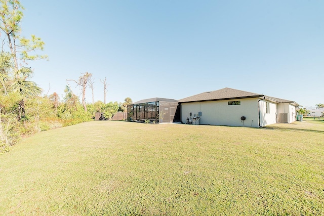 view of yard with central AC unit and a lanai