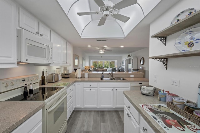 kitchen with sink, white cabinets, white appliances, and light hardwood / wood-style flooring