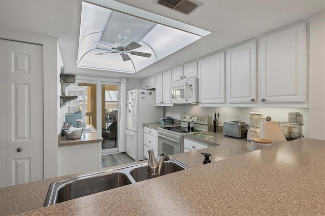 kitchen with ceiling fan, sink, white appliances, white cabinets, and light wood-type flooring