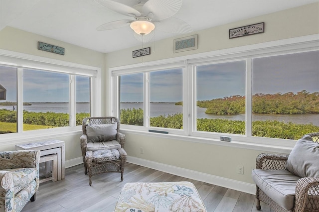 sunroom / solarium featuring ceiling fan, plenty of natural light, and a water view