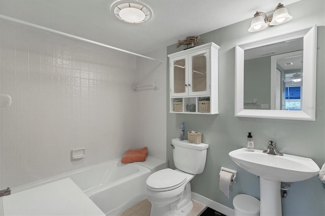 bathroom with toilet and tiled shower / bath