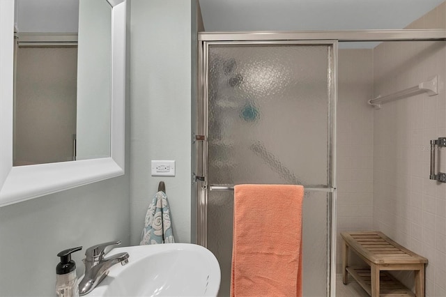 bathroom with sink and a shower with shower door