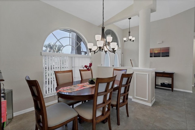 tiled dining space with vaulted ceiling and a notable chandelier