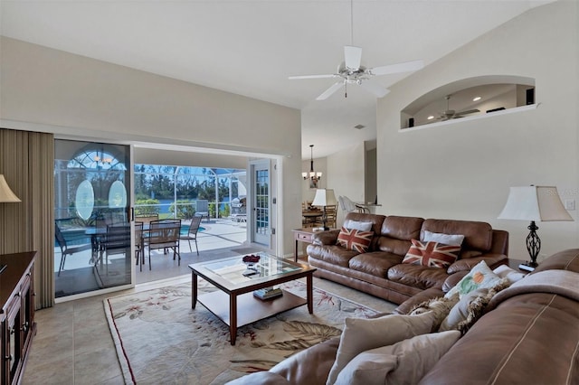 living room featuring light tile patterned floors, ceiling fan with notable chandelier, and vaulted ceiling