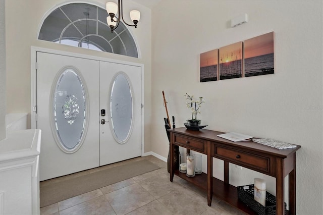 entrance foyer with light tile patterned floors and an inviting chandelier