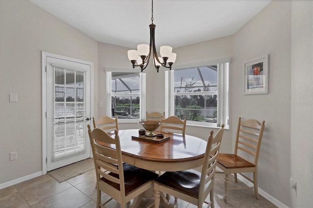 tiled dining room featuring plenty of natural light and a chandelier