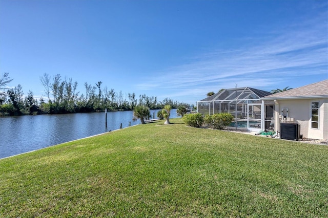 view of yard with a water view, a lanai, and central air condition unit