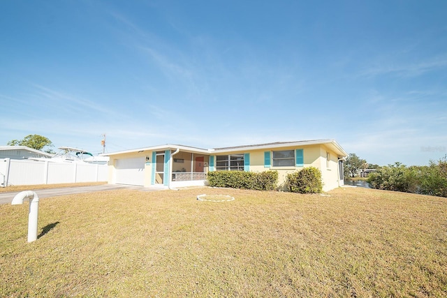 ranch-style house featuring a front yard and a garage